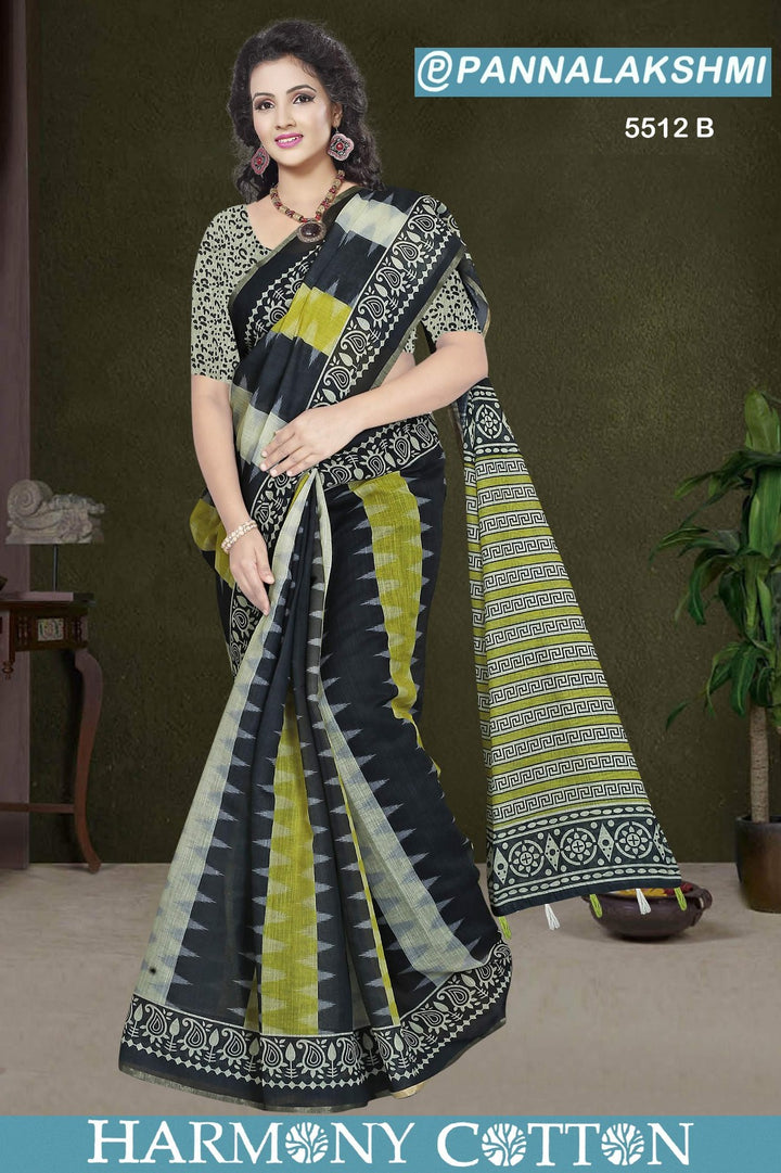 Woman wearing a black and green saree with a patterned border, standing against a plain background.